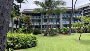A hotel with a multi-story building, balconies, and lush landscaping.