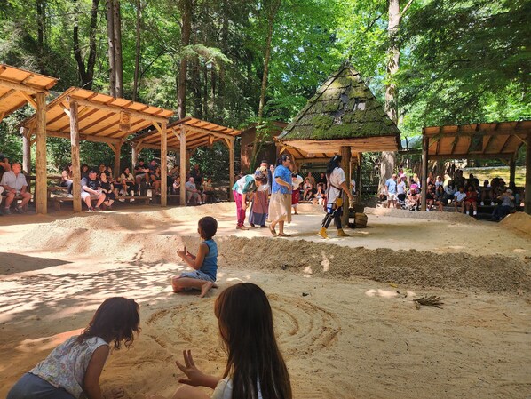 Un espacio al aire libre con arena, estructuras de madera y gente.