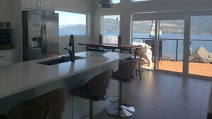 A modern kitchen with a large island, bar stools, and a view of the lake.