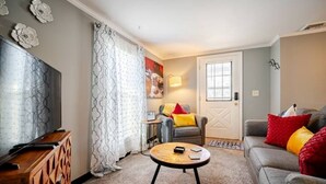 A living room with a sofa, a coffee table, a TV, and a cabinet. - Newly Remodeled 1-BR Close to Everything yet Very Private (Wallingford)