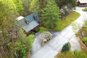 Situated in a serene wooded area, this cabin offers a tranquil setting surrounded by lush greenery and a well-maintained lawn.