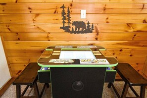 Cozy retreat with a table for games and a bear-themed poster on the wall.