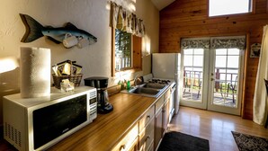 A kitchen with a microwave, coffee maker, and sink. There is a fish decoration on the wall and a window with curtains. -  'Chisik Cabin'  Waterfront/Sunset Views (Kasilof)