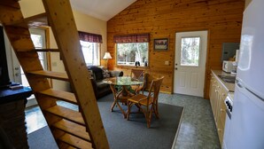 A cabin interior with a dining area, kitchen, and a staircase. - 'Cape Kasilof Cabin'  Waterfront/Sunset Views  (Kasilof)