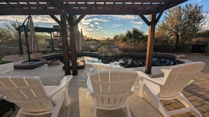 A covered outdoor seating area with Adirondack chairs, a small pond, and a pergola structure. - A D O B E  -  E S T A T E (Mesa)
