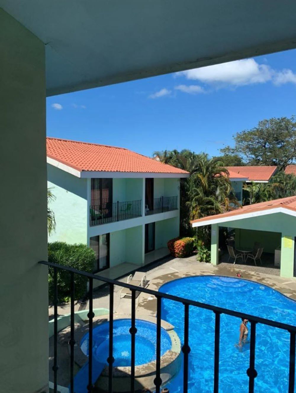 Un hotel con piscina, un espacio exterior cubierto y vistas de los edificios circundantes.
