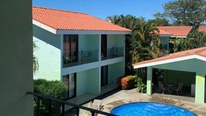 A hotel with a swimming pool, a covered outdoor area, and a view of the surrounding buildings. - Villa Riviera (Sardinal)