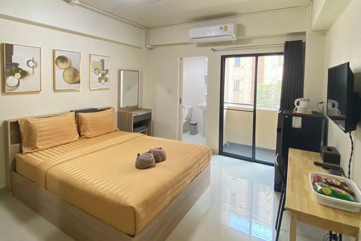 Une chambre d’hôtel avec un lit, une petite table sur laquelle se trouve un panier, une télévision et un appareil de climatisation.
