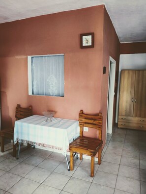 Cozy room with a single bed, two chairs, and a small table, perfect for a relaxing stay.