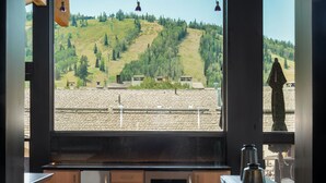 A kitchen with a large window overlooking a forested hillside. - Unrivaled Luxury Penthouse Ski In Ski Out 3 Bed+Den Modern Views Silver Lake Village Deer Valley (Park City)
