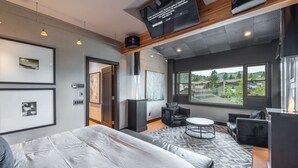 A modern hotel room with a large bed, a seating area with a round table, and a large window offering a view of the outdoors. - Unrivaled Luxury Penthouse Ski In Ski Out 3 Bed+Den Modern Views Silver Lake Village Deer Valley (Park City)