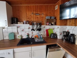 Eine Küche mit Holzschränken, einer Spüle, einem Toaster und einer Kaffeemaschine.