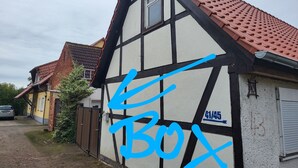 A traditional half-timbered house with a sloped red-tiled roof, a satellite dish, and a garage door. - Fitter and guest house in Groß Rossau - entire house (Osterburg (Altmark))