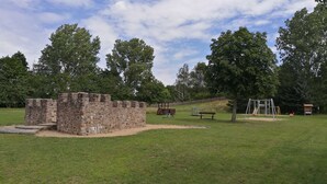 A park with stone structures, a playground, and a wooden bench. - Fitter and guest house in Groß Rossau - entire house (Osterburg (Altmark))