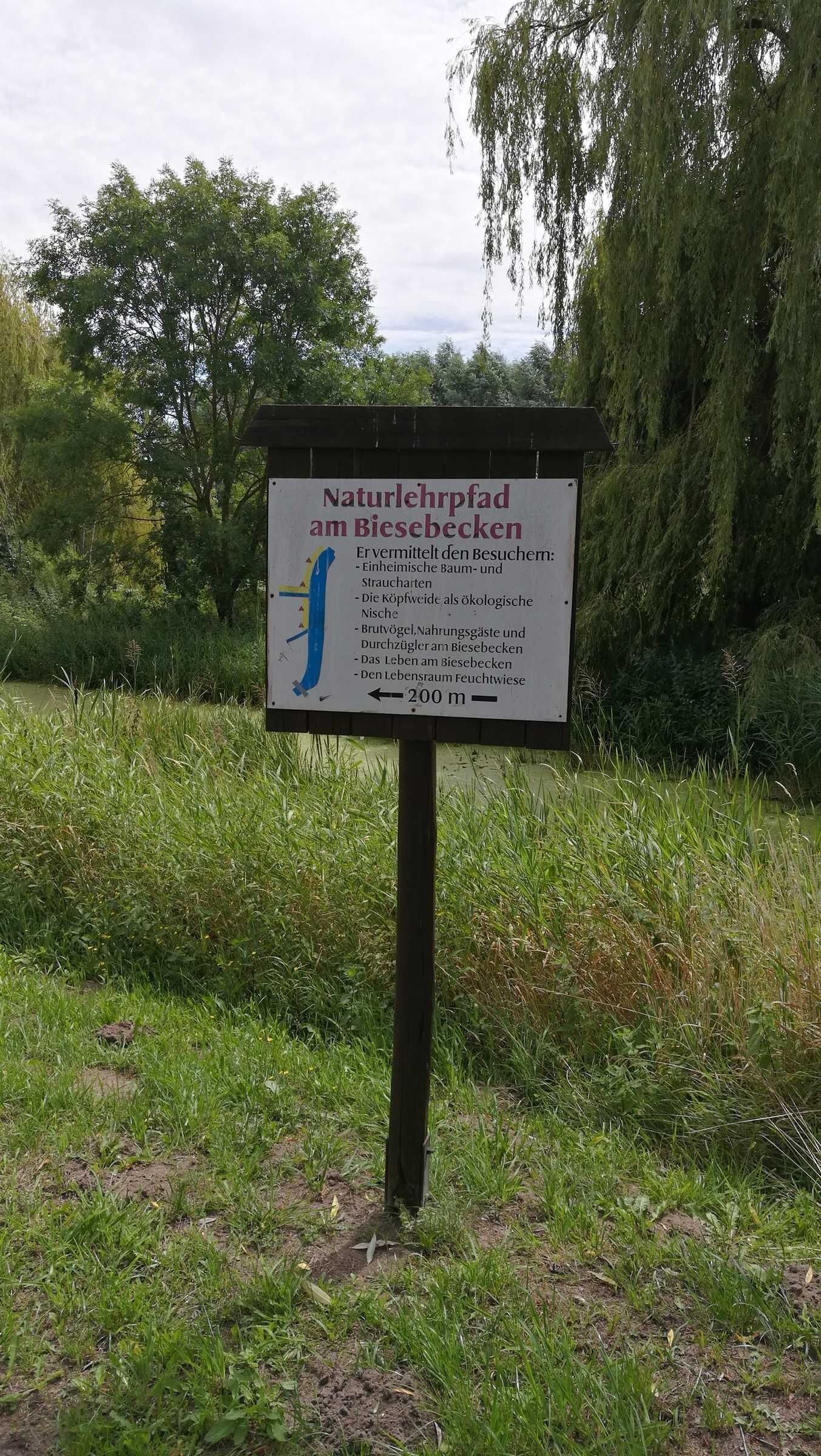 Un cartel con texto en alemán que indica un parque natural y sus características.