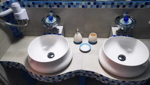 A bathroom with two sinks, a towel rack, and a mirror. -       BLUE SUITE     (Santorini)