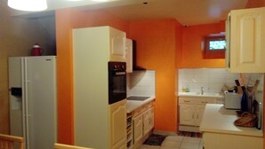 Une cuisine de taille réduite avec des meubles blancs, un four encastré et un évier.