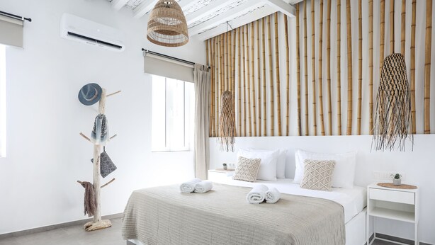Un dormitorio moderno con una cama grande, cabecera de madera y diseño minimalista.