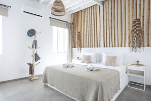 A modern bedroom with a large bed, a wooden headboard, and a minimalist design.