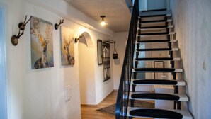 A staircase with a black railing leading to an upper floor. - Bauernhaus am Sallingbach (Rohr in Niederbayern)