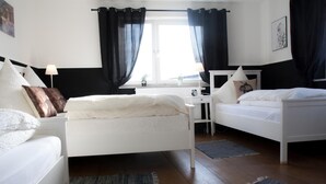 A modern bedroom with two single beds, a desk, and a chair. - Bauernhaus am Sallingbach (Rohr in Niederbayern)