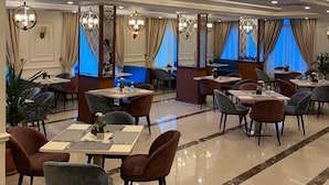 A spacious dining area with multiple tables and chairs, elegant chandeliers, and a polished floor. - Jewel Zamalek Hotel (Cairo)