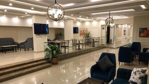 A modern lobby with a glass railing, seating area, and a television screen. - Jewel Zamalek Hotel (Cairo)