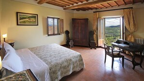 Ein Schlafzimmer mit Bett, Schreibtisch, Stuhl, Kleiderschrank und einem Fenster mit Blick.