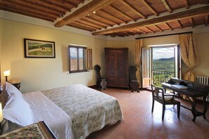 Quarto com cama, escrivaninha, cadeira, guarda-roupa e janela com vista.