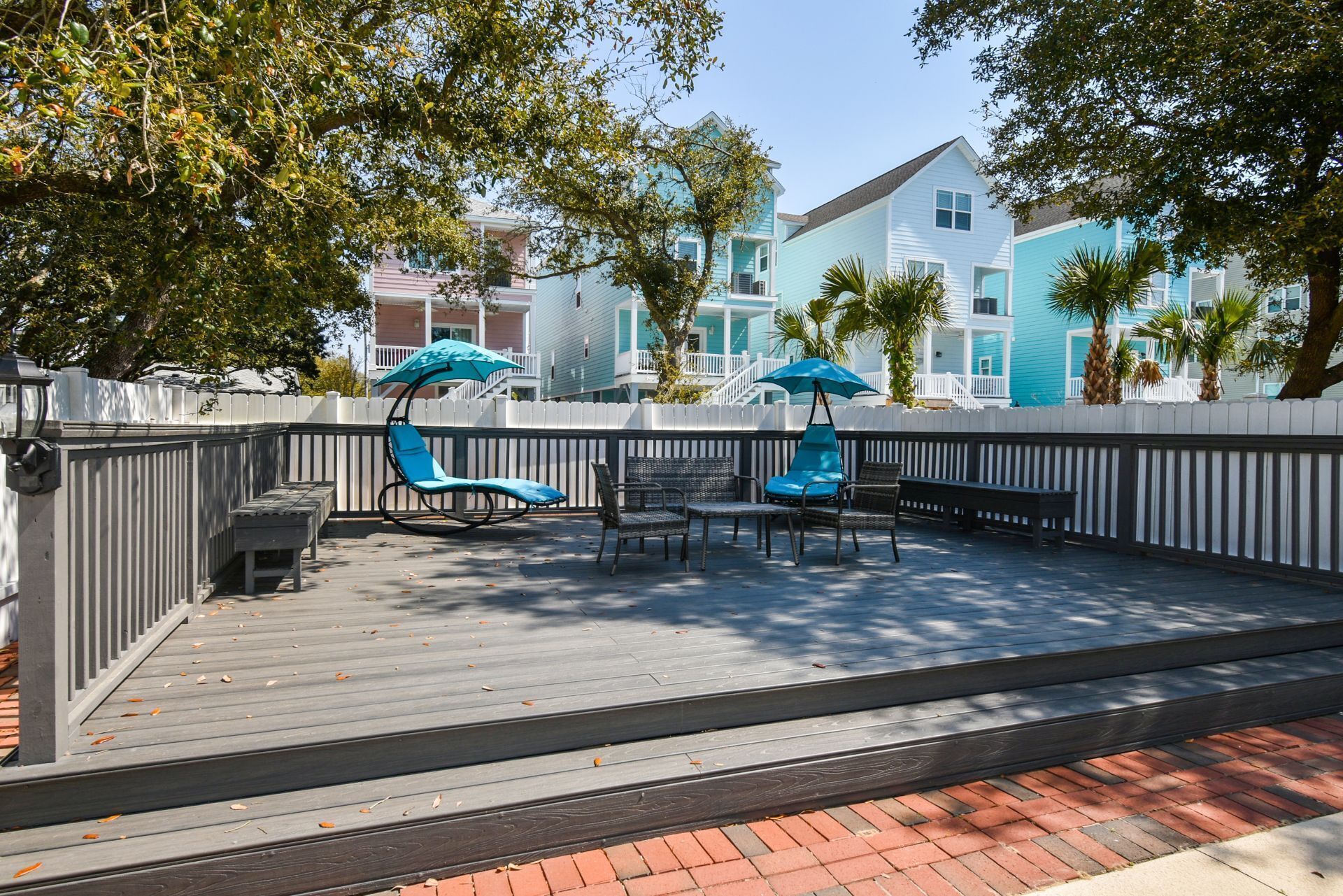 An outdoor deck with a seating area, including a table and chairs, and a swing chair.