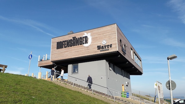 A modern building with a sign reading "HAFENSANGER" and "BARTEL". - Semi-detached house with a large patio, 200 m from downtown, 1,000 m from the beach, Wi-Fi (Dornumersiel)