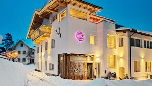 Un edificio de varios pisos con fachada temática de esquí, que incluye un letrero de neón y una estructura de telesilla.