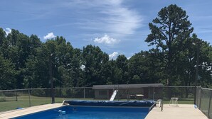 Una piscina rectangular con revestimiento azul, rodeada por un solárium de hormigón.