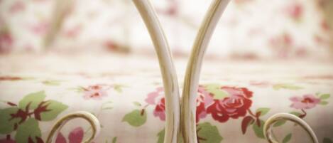 A close-up of a floral-patterned fabric with a white background and pink and red flowers.
