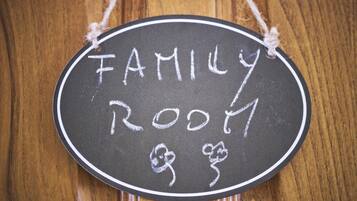 A chalkboard sign with "FAMILY ROOM" written on it, surrounded by a simple rope border.