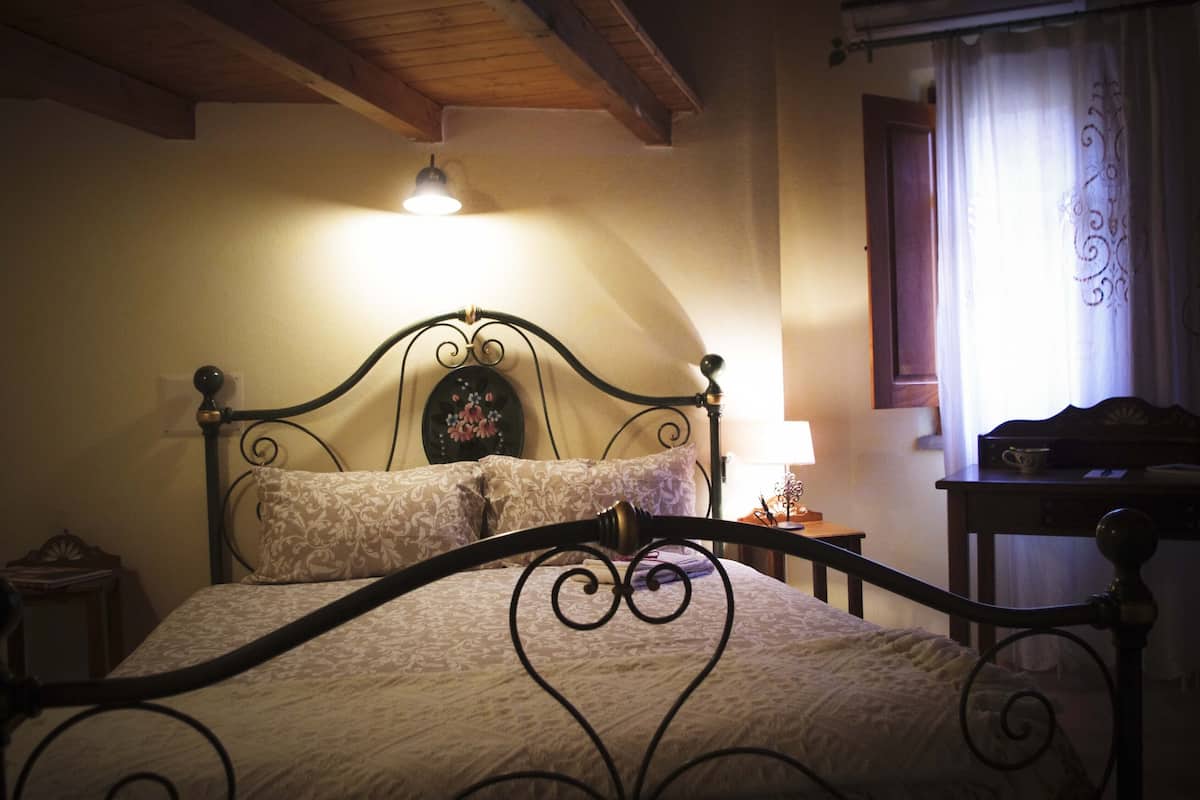 A bed with a headboard, a bedside table, and a lamp.
