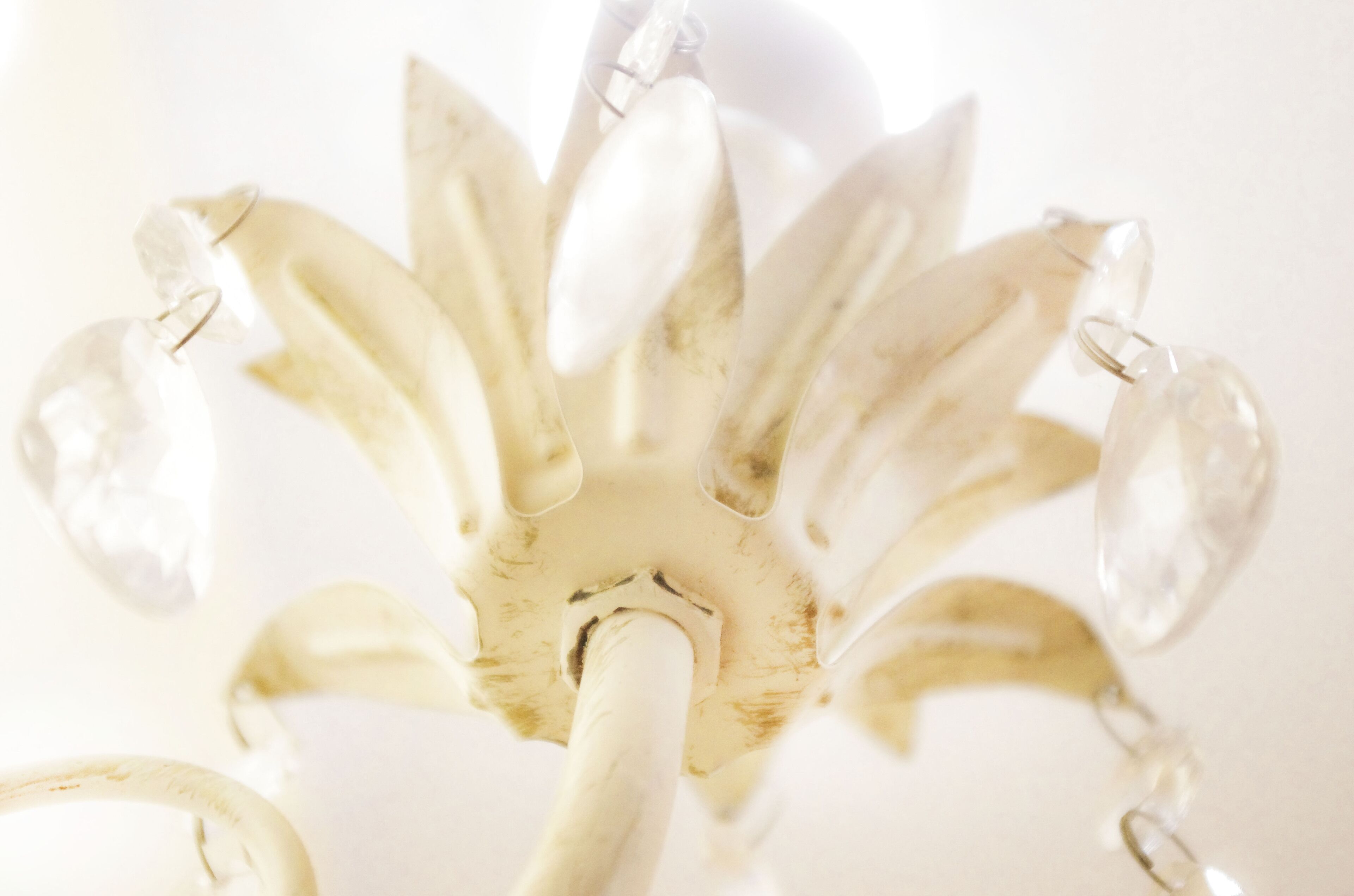 Un lustre composé de plusieurs éléments en verre transparent et doté d’une structure centrale blanche.