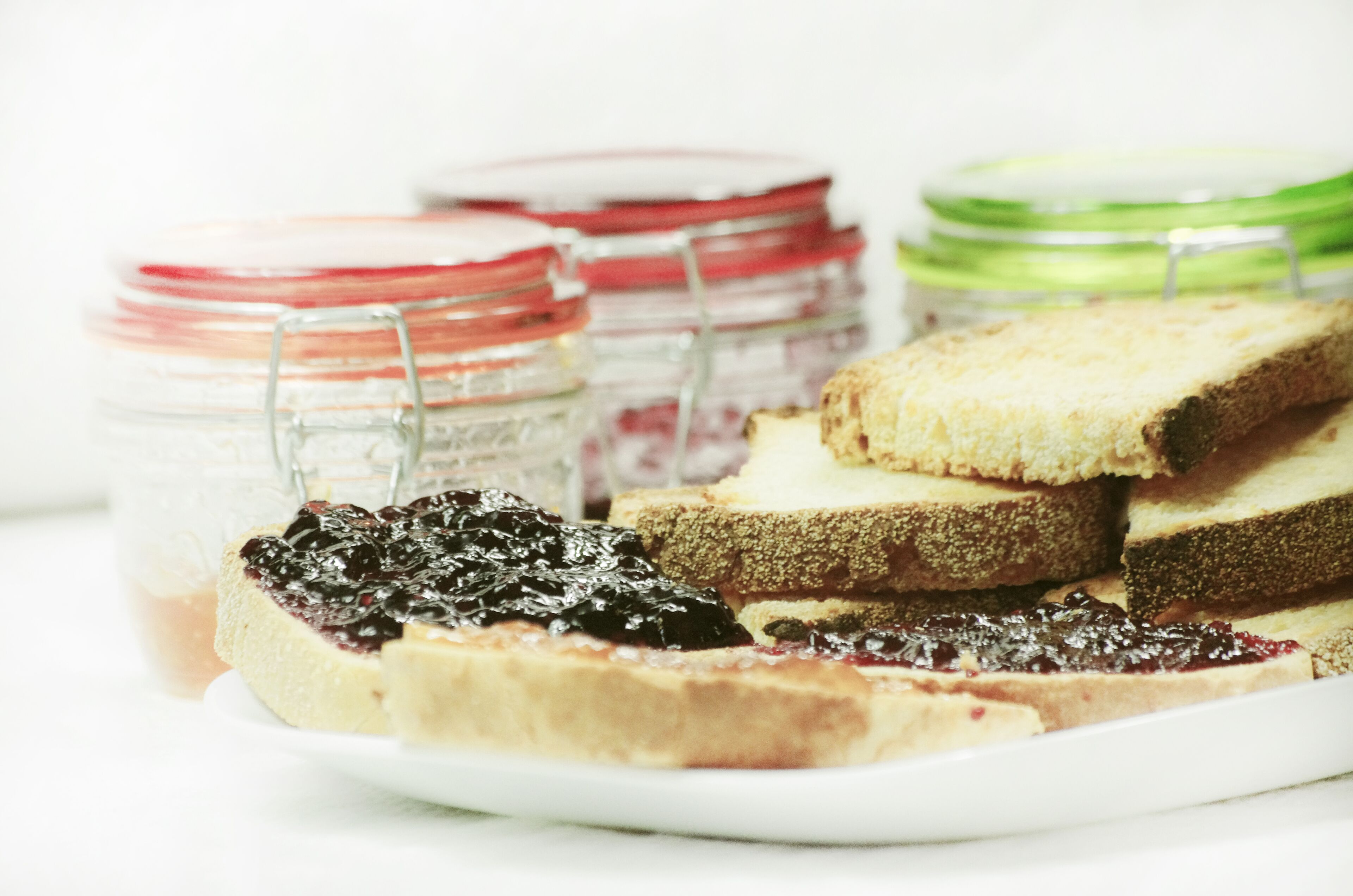 A plate with various types of bread and jams.