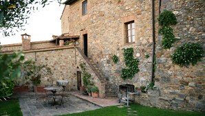 A stone building with a patio area featuring outdoor furniture and a grill. - CANONICA 43 Luxury villa in the heart of Tuscany (colle di val d'elsa)