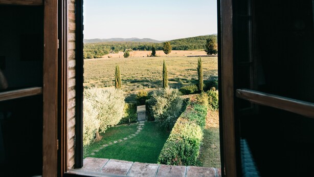 A view from a window of a garden with a pathway, trees, and a distant landscape. - CANONICA 43 Luxury villa in the heart of Tuscany (colle di val d'elsa)