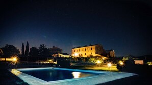 A nighttime view of a swimming pool with a large building in the background. - CANONICA 43 Luxury villa in the heart of Tuscany (colle di val d'elsa)