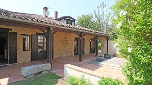 A rustic building with a tiled roof, wooden beams, and a covered patio area. - Character cottage, large garden and swimming pool, tranquility guaranteed (Sérignac-Péboudou)