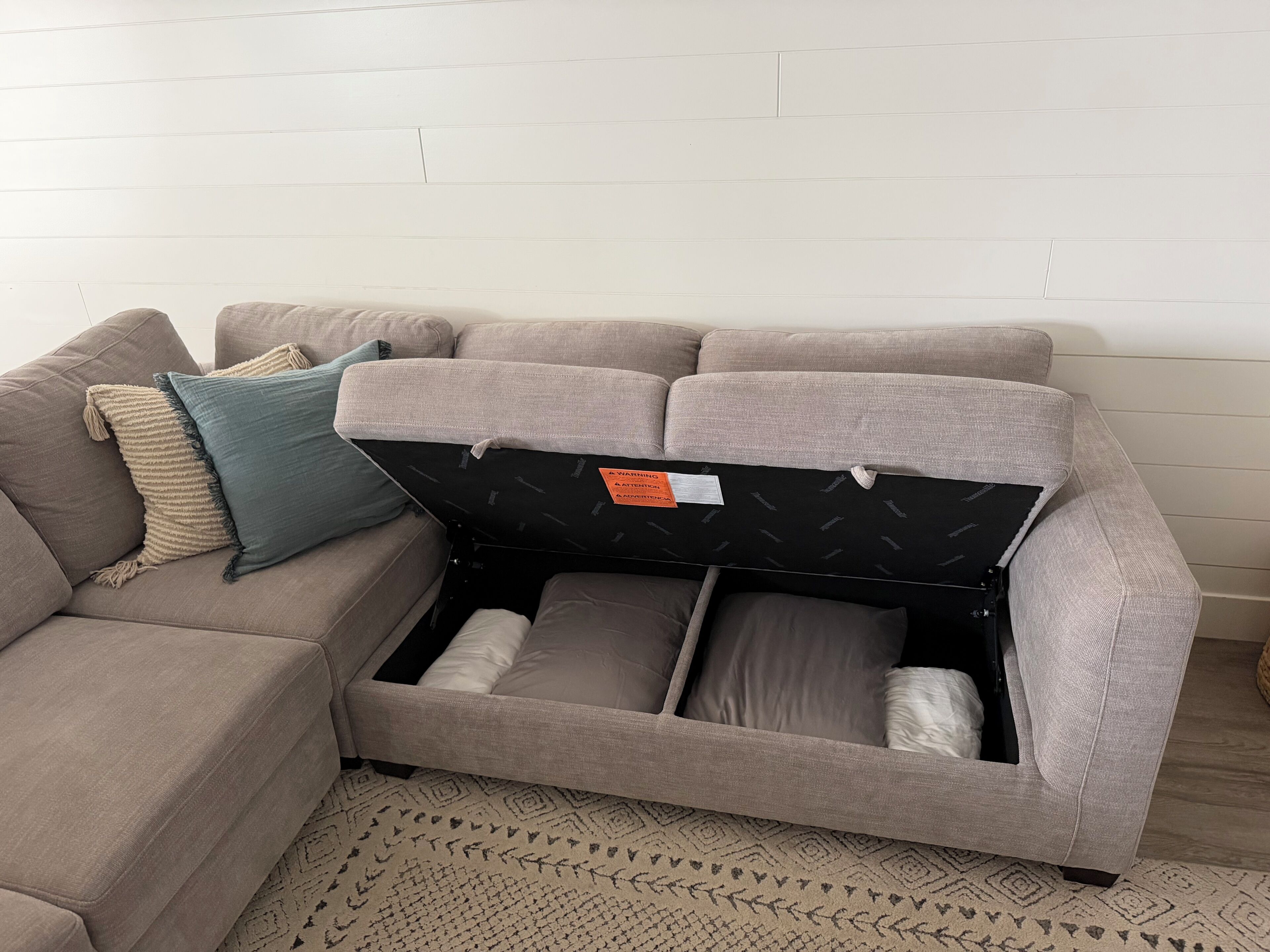 A sectional sofa with a storage compartment underneath.