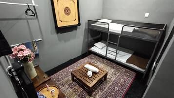 Cozy retreat with a bunk bed, stool, and patterned rug.