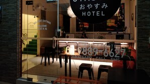 The entrance of Oyasumi Hotel with a reception desk, a phone, and a sign indicating room rates. - Oyasumi Hotel (Kulim)