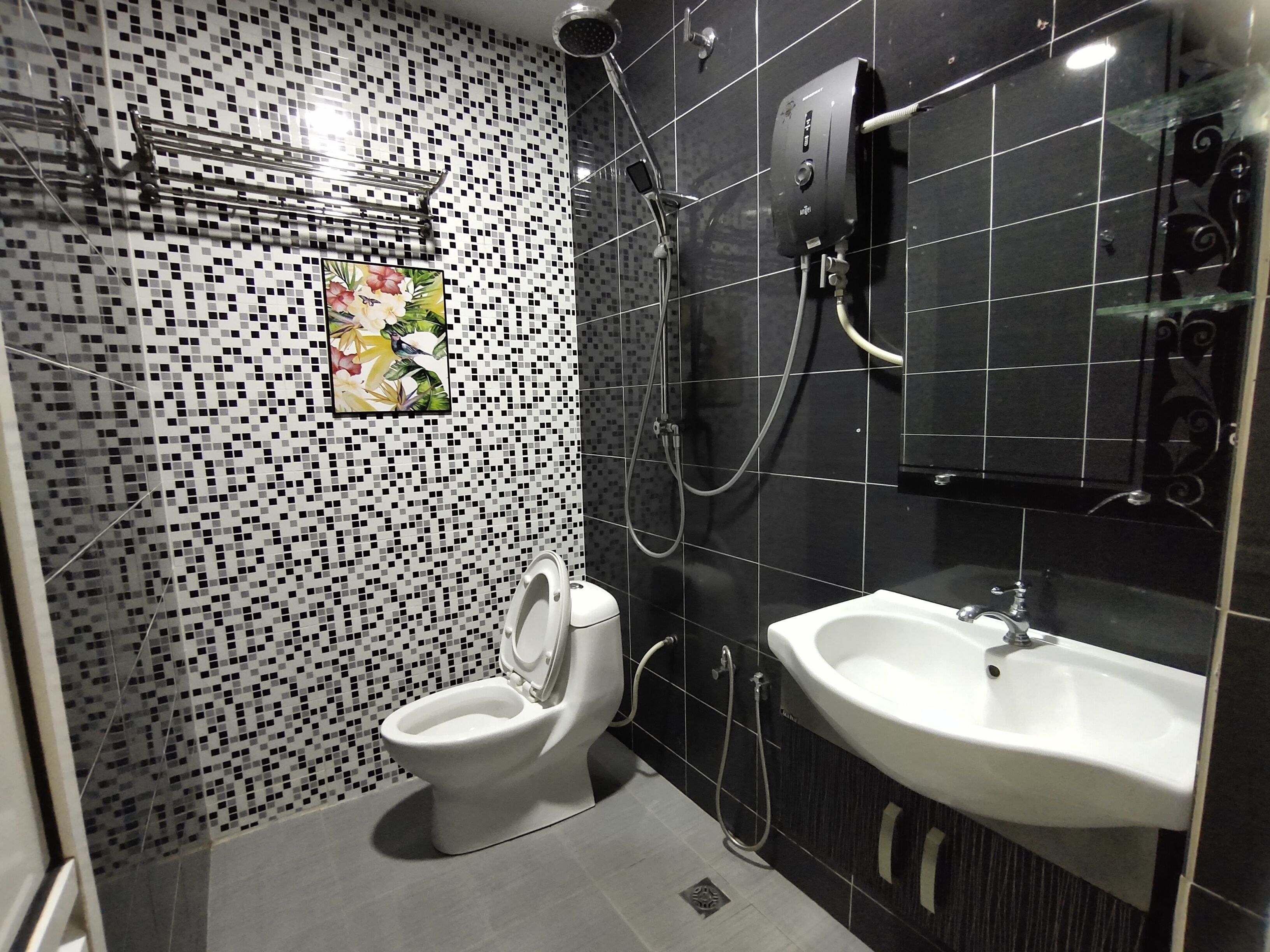 Casa de banho moderna com sanita, chuveiro e lavatório.