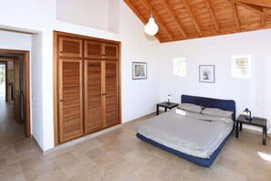 Ein Schlafzimmer mit einem großen Bett, einem Holzschrank und einem Deckenventilator.