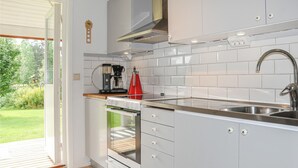 A modern kitchen with white cabinets, a stainless steel sink, and a built-in oven. - Nice home in Torsby with kitchen (Torsby)