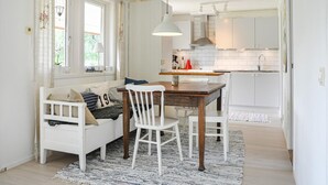 A cozy dining area with a white table and chairs, a patterned rug, and a window with curtains. - Nice home in Torsby with kitchen (Torsby)