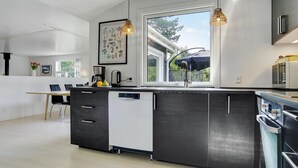 Una cucina moderna con un'isola grande, un'area pranzo e vista sull'esterno.